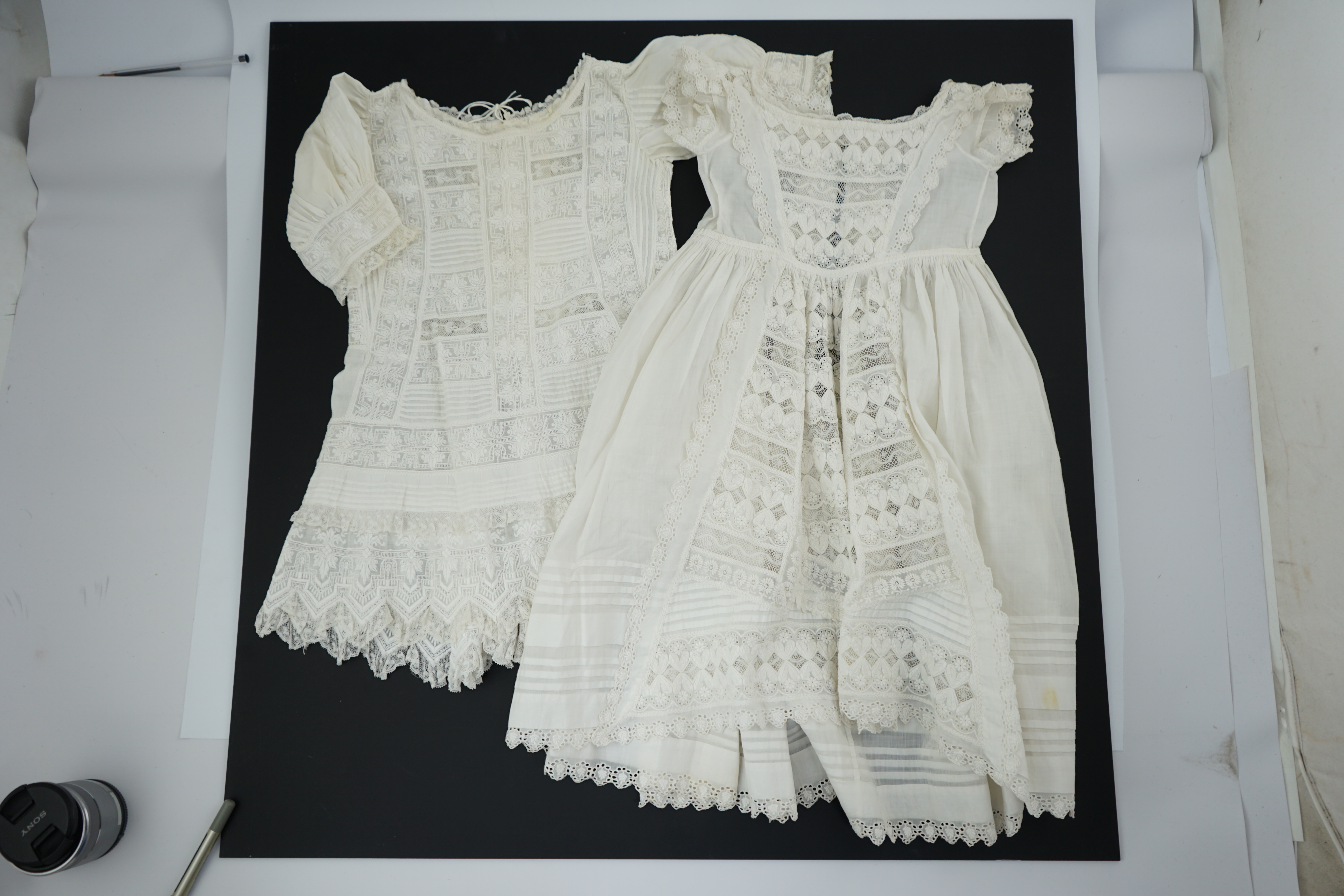 Two unusual 19th century intricately white worked children’s dresses, one hand worked with fine panels of white work, feather stitching and tucking, edged and inserted with hand made Valenciennes lace, the other worked i